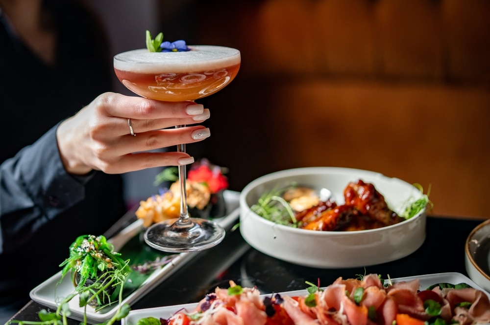 Female,Hand,Holding,Glass,With,Cocktail,In,Restaurant